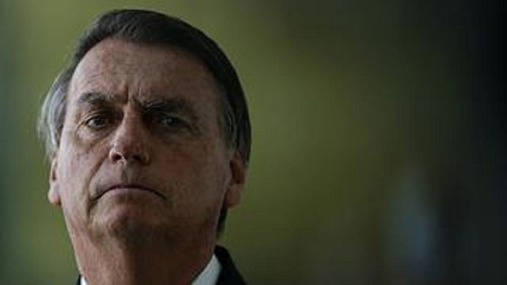 Jair Bolsonaro sério, no canto esquerdo da foto, em close