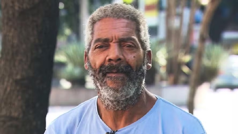 O músico Edson Bernardo de Lima, conhecido como Café, olhando para a câmera, de camiseta azul clara