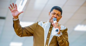 apóstolo Valdemiro Santiago de olhos fechados, falando em microfone e gesticulando, de roupa de frio marrom