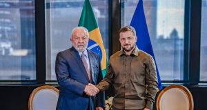 O presidente Lula e o presidente da Ucrânia, Volodymyr Zelensky, em aperto de mãos, posando para foto em pé