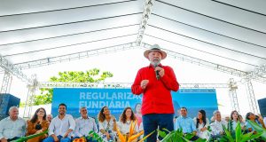 O presidente Luiz Inácio Lula da Silva (PT) de roupa vermelha e chapéu, falando em microfone