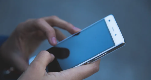 Mão mexendo em celular