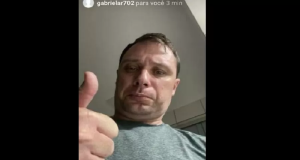 Mauro Cid no meio de montagem fazendo sinal de joia para a câmera