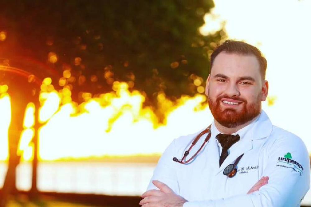 Bruno Gossler Schmidt sorrindo de jaleco e braços cruzados, no canto direito de foto