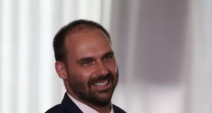 Eduardo Bolsonaro (PL-SP) rindo sem olhar para a câmera