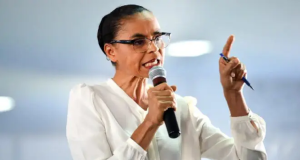 ministra do Meio Ambiente, Marina Silva, falando em microfone, séria