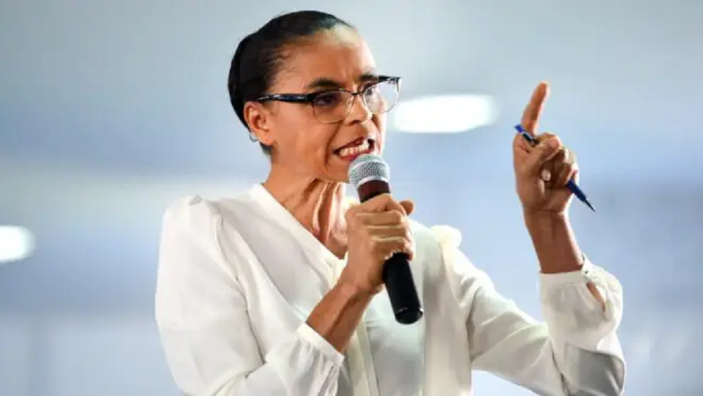 ministra do Meio Ambiente, Marina Silva, falando em microfone, séria