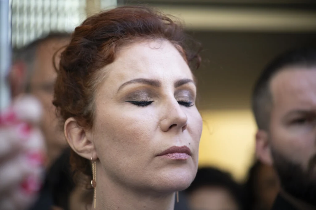 deputada Carla Zambelli (PL-SP) de olhos fechados, séria, em close, de cabelo preso