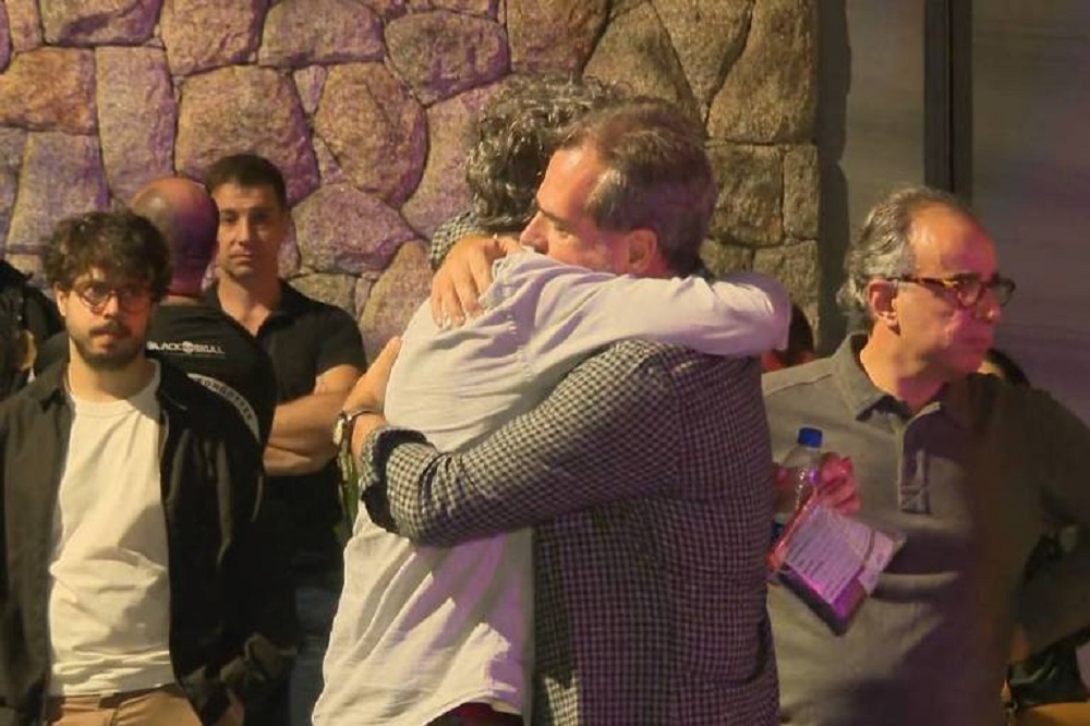 Pessoas se abraçando e sérias