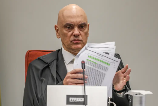 ministro do Supremo Tribunal Federal (STF) Alexandre de Moraes sério, mexendo em papeis