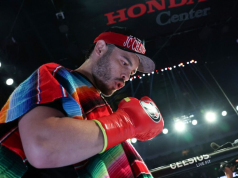 boxeador mexicano Julio César Chávez Jr. olhando pra baixo, no ringue, de boné e luvas