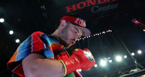boxeador mexicano Julio César Chávez Jr. olhando pra baixo, no ringue, de boné e luvas