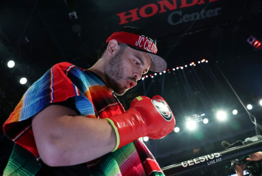 boxeador mexicano Julio César Chávez Jr. olhando pra baixo, no ringue, de boné e luvas
