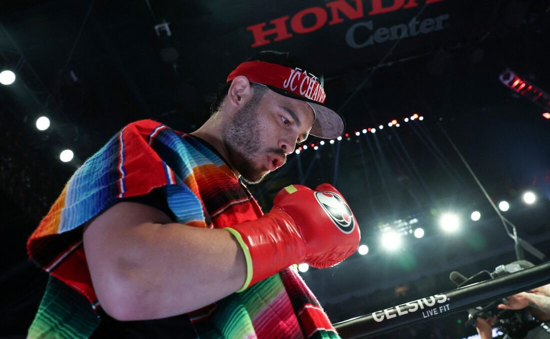 boxeador mexicano Julio César Chávez Jr. olhando pra baixo, no ringue, de boné e luvas