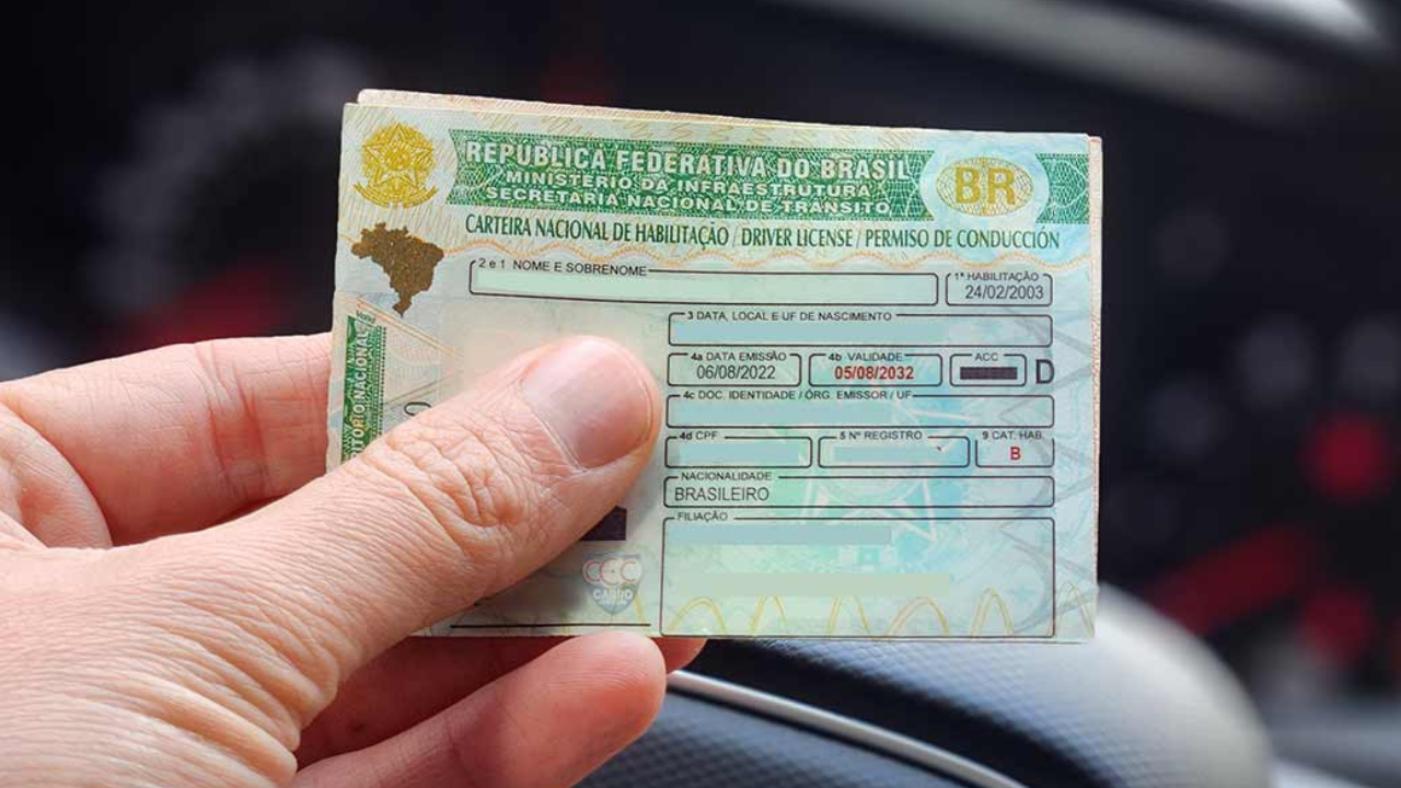 Mão segurando CNH