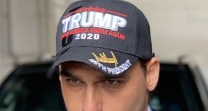 Eduardo Bolsonaro com boné de Trump, sério, em close, sem olhar para a câmera