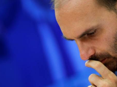 deputado federal licenciado Eduardo Bolsonaro (PL-SP) no canto direito da foto, cabisbaixo, sério, com uma mão na boca
