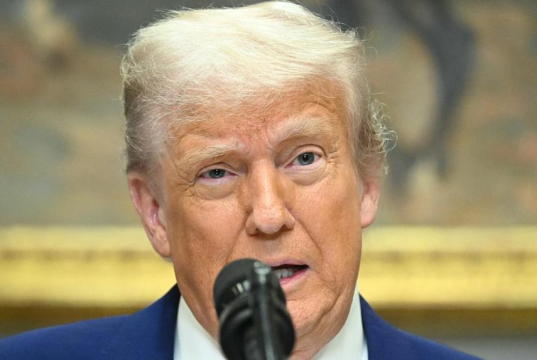 presidente dos Estados Unidos, Donald Trump, em close, falando em microfone, sério, olhando pra frente