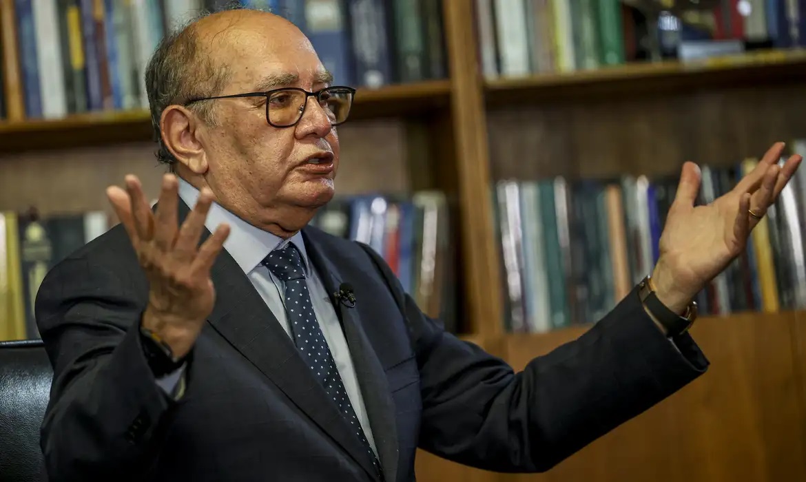 ministro do STF Gilmar Mendes com os braços abertos, falando
