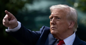 Donald Trump apontando pra frente, sério, de perfil