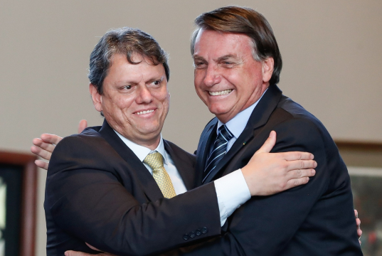Tarcísio de Freitas e Jair Bolsonaro se abraçando e rindo