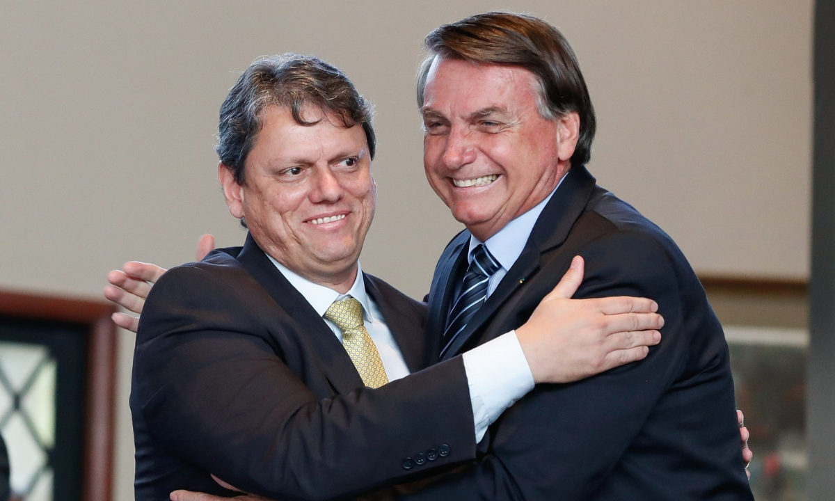 Tarcísio de Freitas e Jair Bolsonaro se abraçando e rindo