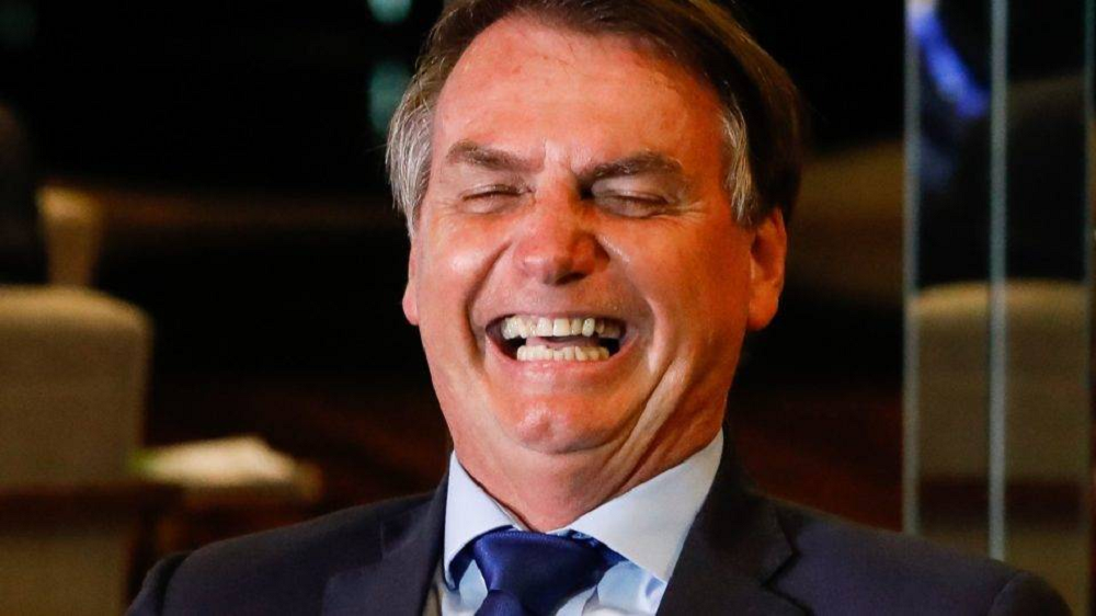 Jair Bolsonaro rindo de olhos fechados, em close
