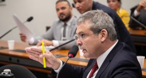 O líder do PT na Câmara, Lindbergh Farias, falando em microfone, de perfil, sério, gesticulando