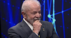 presidente Luiz Inácio Lula da Silva (PT) com a mão no queixo, sorrindo, sem olhar para a câmera