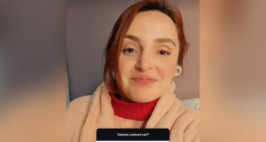 Regiane Cichelero Werlang de roupa vermelha e bege, de cabelo preso, sorrindo timidamente para a câmera