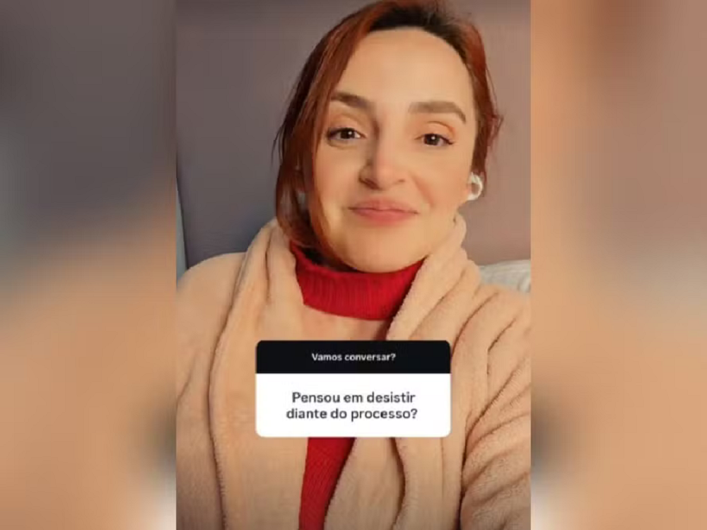 Regiane Cichelero Werlang de roupa vermelha e bege, de cabelo preso, sorrindo timidamente para a câmera