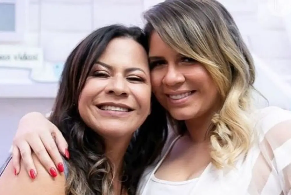 Ruth Moreira e Marília Mendonça abraçadas, sorrindo para a câmera, lado a lado