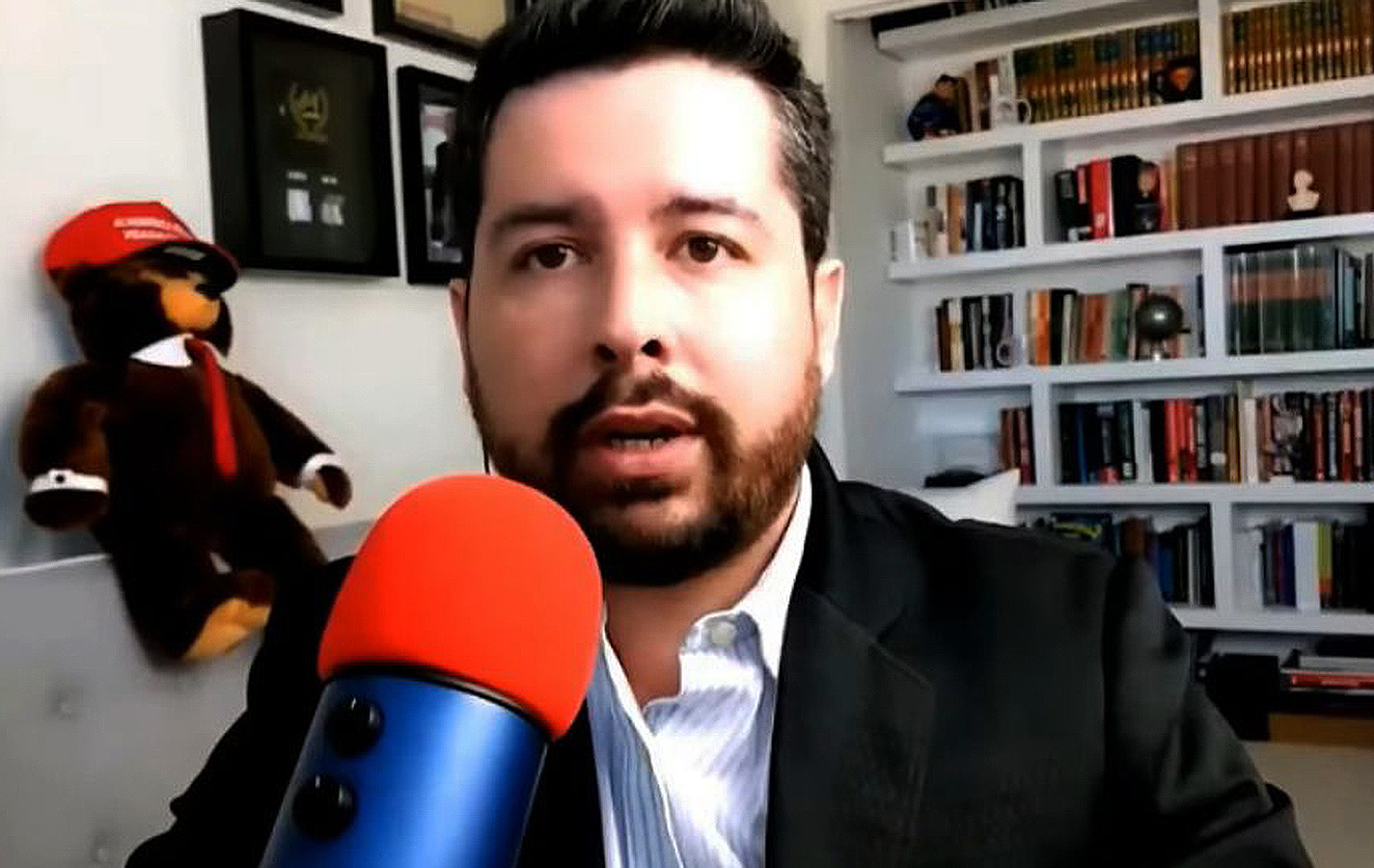 Paulo Figueiredo falando em microfone, sério