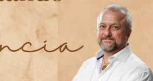 professor de yoga Uberto Gama de roupa branca, posando para foto com sorriso tímido