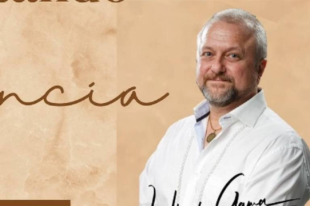 professor de yoga Uberto Gama de roupa branca, posando para foto com sorriso tímido