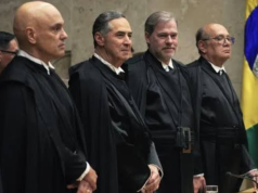 Ministros do STF lado a lado, em pé, sem olhar para a câmera