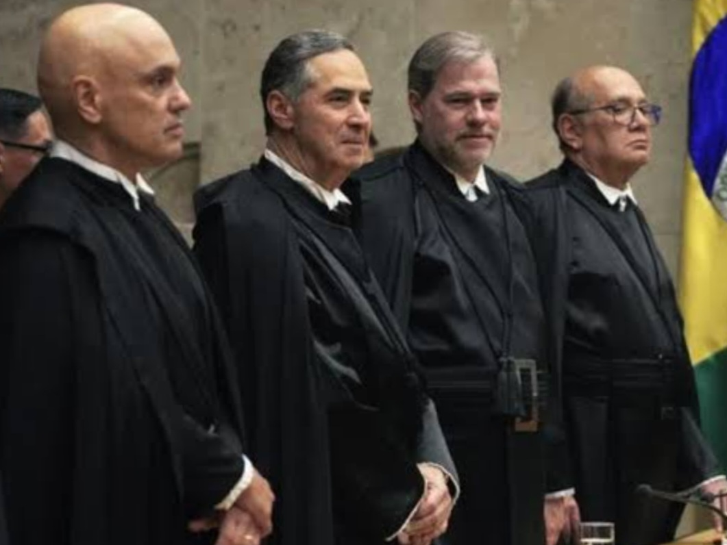 Ministros do STF lado a lado, em pé, sem olhar para a câmera