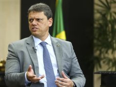 O governador de São Paulo, Tarcísio de Freitas (Republicanos), sério, falando, gesticulando e olhando para o lado