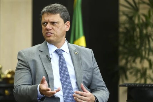 O governador de São Paulo, Tarcísio de Freitas (Republicanos), sério, falando, gesticulando e olhando para o lado