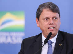governador de São Paulo, Tarcísio de Freitas, falando em microfone e olhando para o lado, sério