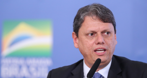 governador de São Paulo, Tarcísio de Freitas, falando em microfone e olhando para o lado, sério