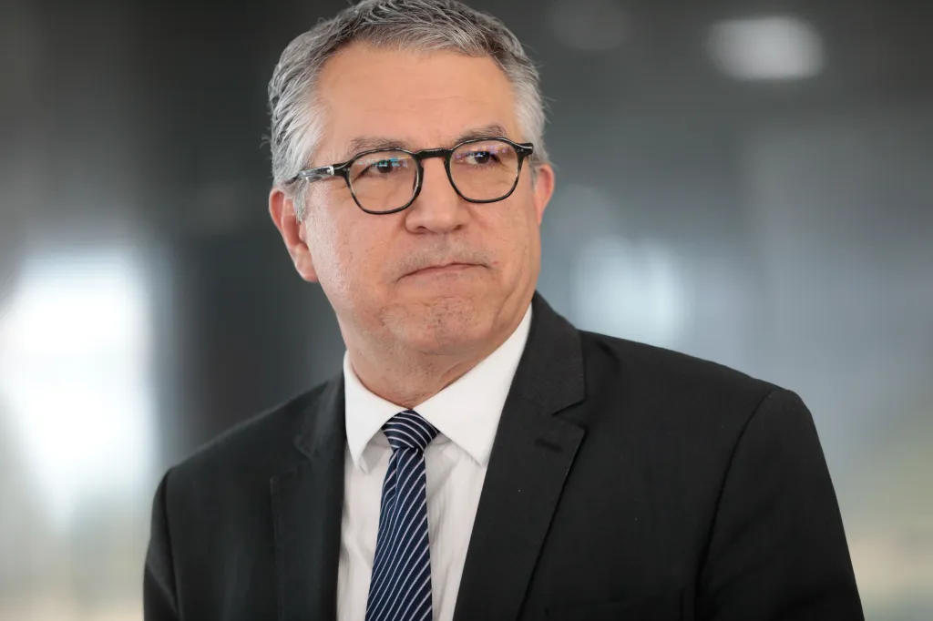 ministro da Saúde, Alexandre Padilha, com expressão pensativa, olhando para o lado, sério, de óculos
