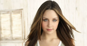 Amanda Bynes ainda na adolescência, de camiseta cinza, posando para foto