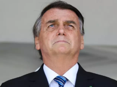 ex-presidente Jair Bolsonaro em close, sério, olhando levemente para cima com expressão de preocupação