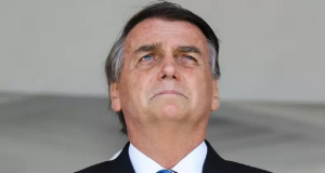 ex-presidente Jair Bolsonaro em close, sério, olhando levemente para cima com expressão de preocupação