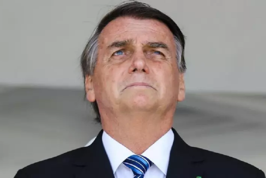ex-presidente Jair Bolsonaro em close, sério, olhando levemente para cima com expressão de preocupação