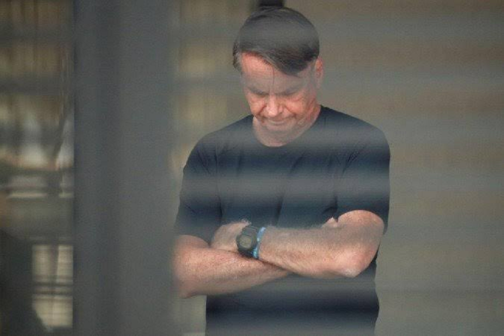 ex-presidente Jair Bolsonaro (PL) de camiseta preta, cabisbaixo, com os braços cruzados