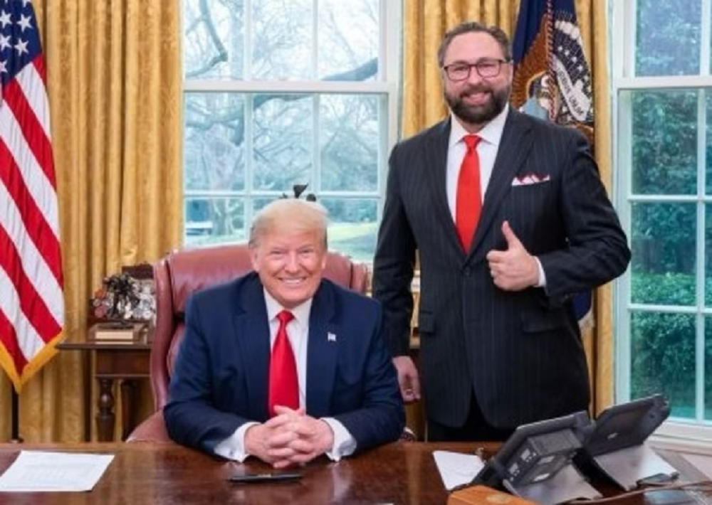 O presidente dos EUA, Donald Trump, e o conselheiro Jason Miller sorrindo para foto
