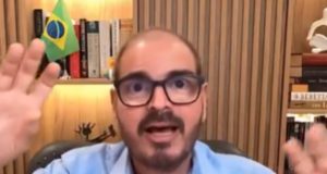 Rodrigo Constantino falando e gesticulando para a câmera, de óculos