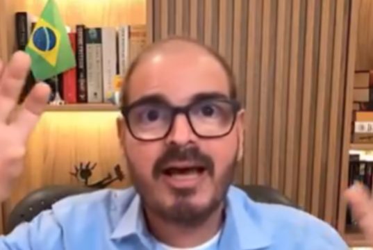 Rodrigo Constantino falando e gesticulando para a câmera, de óculos